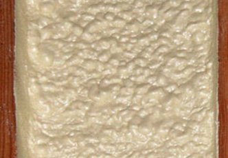 Close-up of a rectangular slice of bread with a slightly textured, uneven surface, reminiscent of the meticulous work of an insulation installer.