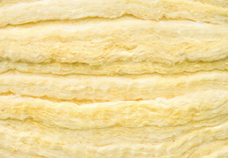 Close-up view of yellow fibrous insulating material with an uneven, layered texture, perfect for your next project with a trusted insulation company.
