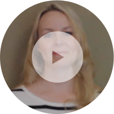 A person with long blonde hair and a black-and-white striped shirt is pictured. A large play button overlay is in the center of the image, suggesting a video about an insulation installer at work.