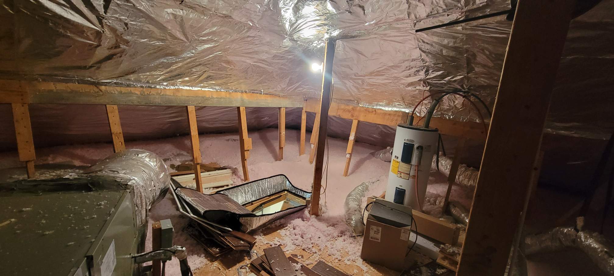 Radiant Barrier and Blown Fiberglass In a attic in Baton Rouge, with blown-in insulation covering the floor.